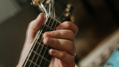Close up of guitar next and player's hand